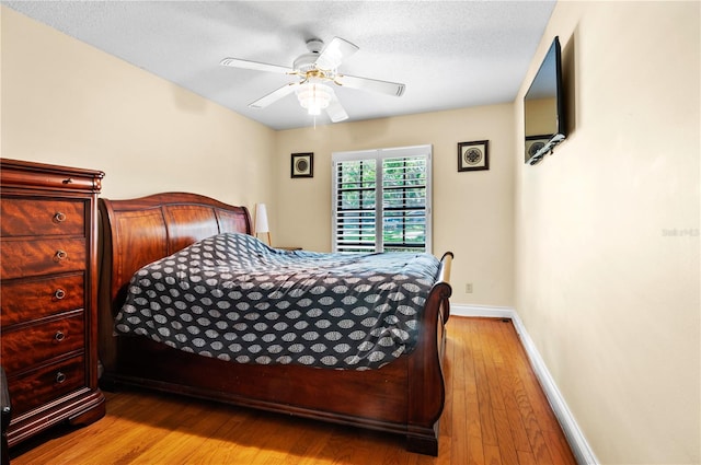 bedroom featuring wood finished floors, a ceiling fan, and baseboards