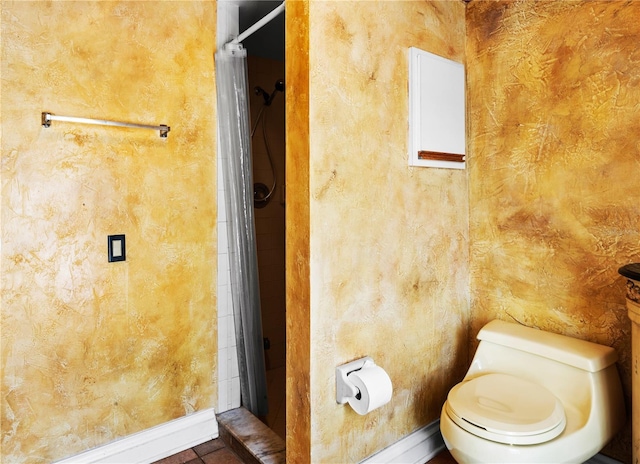 full bath with toilet, curtained shower, and baseboards