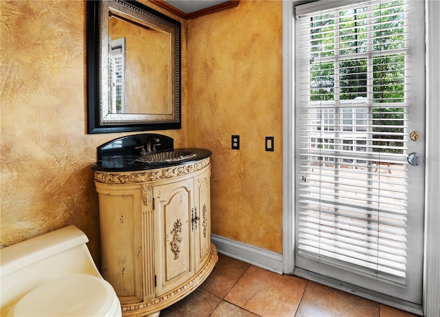 half bath with toilet, baseboards, tile patterned flooring, a textured wall, and vanity