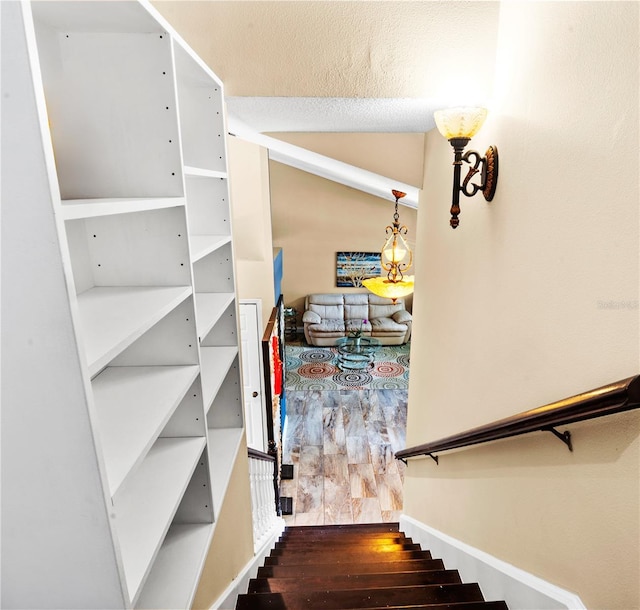 stairs featuring vaulted ceiling and wood finished floors