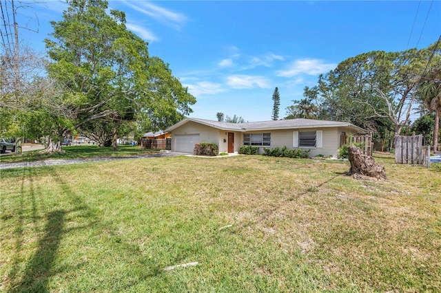 single story home featuring driveway, a front lawn, and a garage