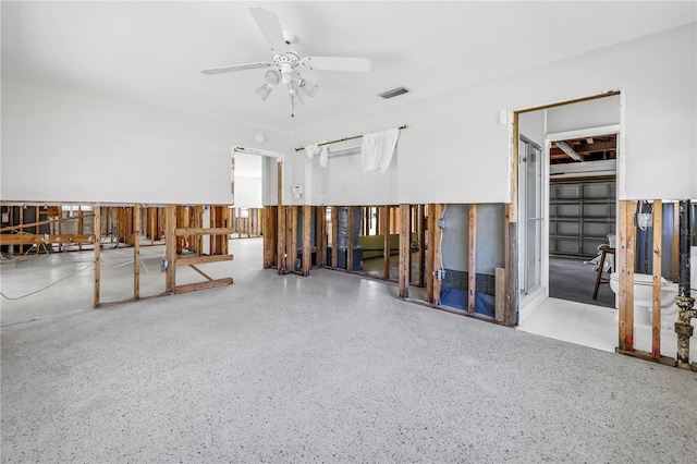 misc room with a ceiling fan, visible vents, and speckled floor