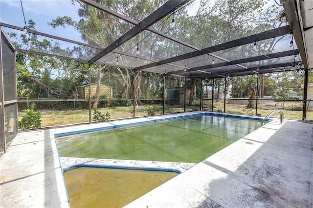 outdoor pool featuring a patio area, a storage unit, and an outbuilding
