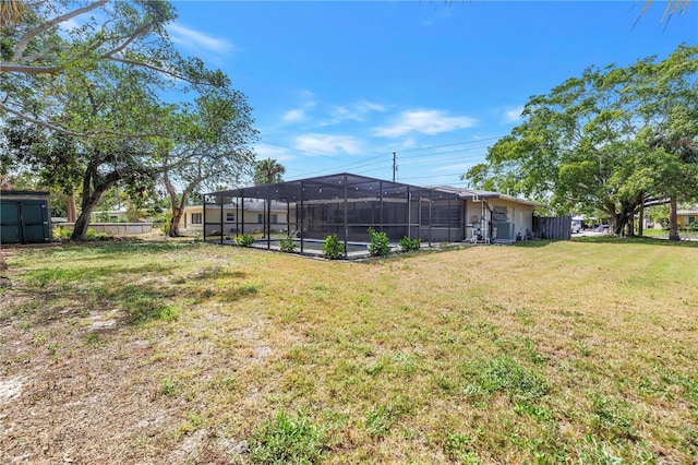 view of yard featuring fence and glass enclosure