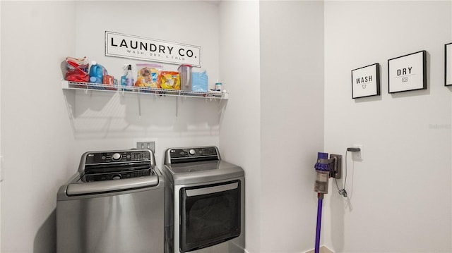 clothes washing area with separate washer and dryer, laundry area, and baseboards