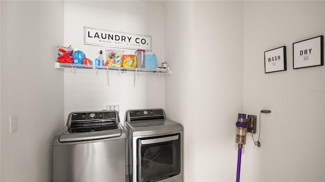 clothes washing area with washing machine and clothes dryer and laundry area