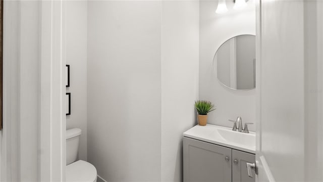 half bath featuring toilet and vanity