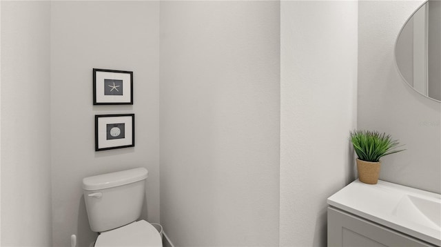 half bathroom featuring vanity and toilet