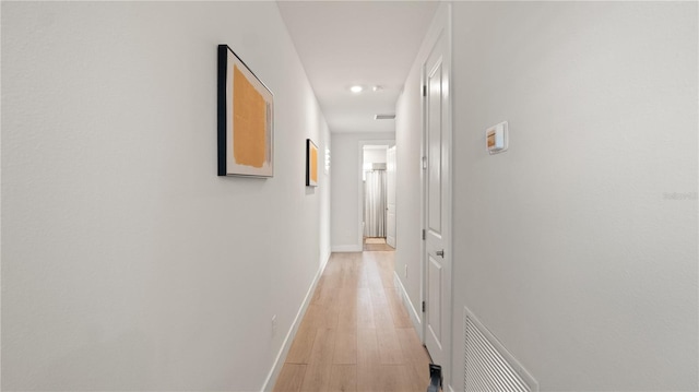 hallway featuring light wood-style flooring, baseboards, visible vents, and recessed lighting