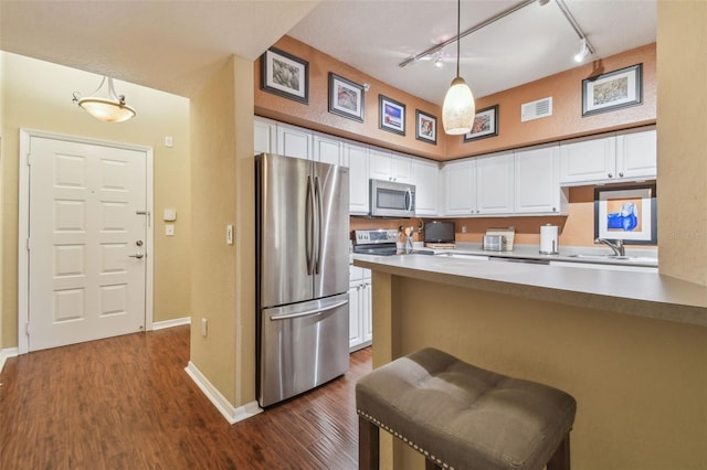 504 S Armenia Ave Unit 1338, Tampa, FL 33609 - kitchen featuring white cabinets, visible vents, stainless steel appliances, dark wood-style flooring, and rail lighting