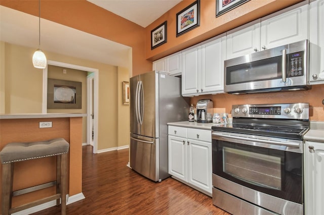 504 S Armenia Ave Unit 1338, Tampa, FL 33609 - kitchen with dark wood-style floors, hanging light fixtures, white cabinets, and appliances with stainless steel finishes