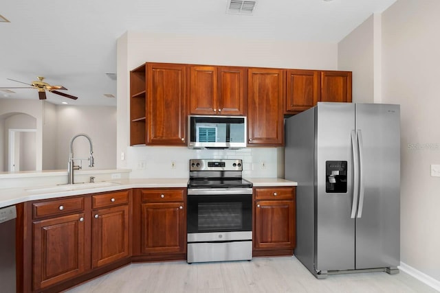 kitchen with a sink, ceiling fan, visible vents, stainless steel appliances, and light countertops