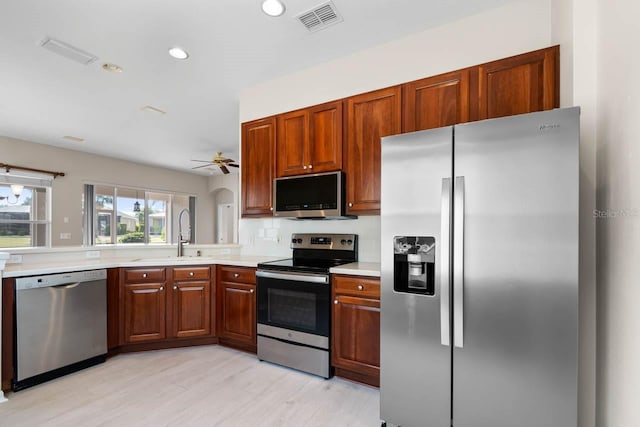 kitchen with a sink, appliances with stainless steel finishes, ceiling fan, visible vents, and light countertops