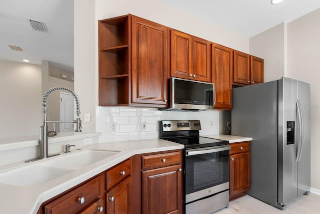 kitchen with a sink, open shelves, visible vents, light countertops, and appliances with stainless steel finishes