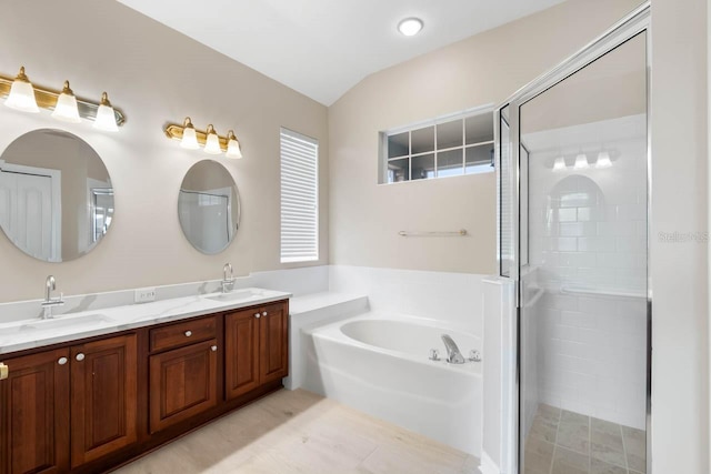 full bathroom featuring double vanity, a garden tub, a shower stall, and a sink