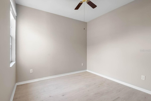 empty room featuring baseboards, a ceiling fan, and light wood finished floors