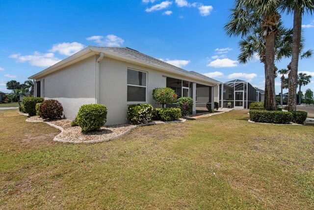 view of side of home with stucco siding and a lawn