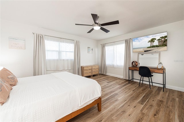 bedroom featuring wood finished floors, baseboards, and ceiling fan