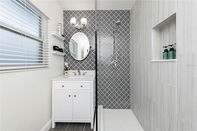 bathroom featuring plenty of natural light, vanity, and tiled shower