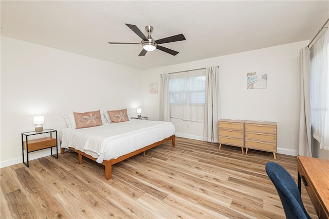 bedroom featuring baseboards, a ceiling fan, and light wood-style flooring