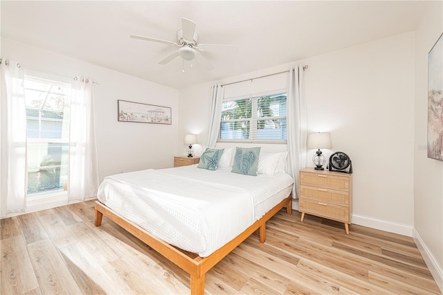 bedroom featuring ceiling fan, baseboards, and light wood-type flooring