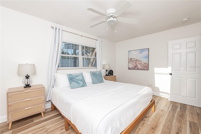 bedroom featuring ceiling fan, baseboards, and light wood-style floors