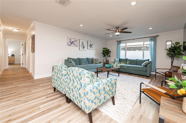 living area featuring crown molding, visible vents, and light wood-style flooring