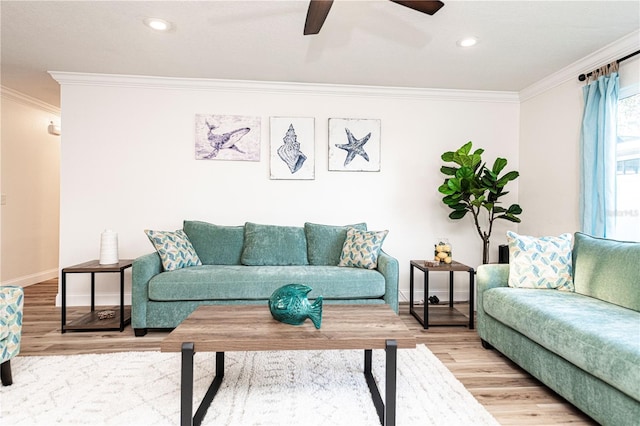 living area featuring ceiling fan, light wood-type flooring, baseboards, and ornamental molding