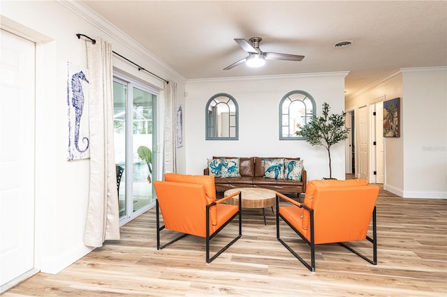 living area with baseboards, crown molding, visible vents, and light wood finished floors