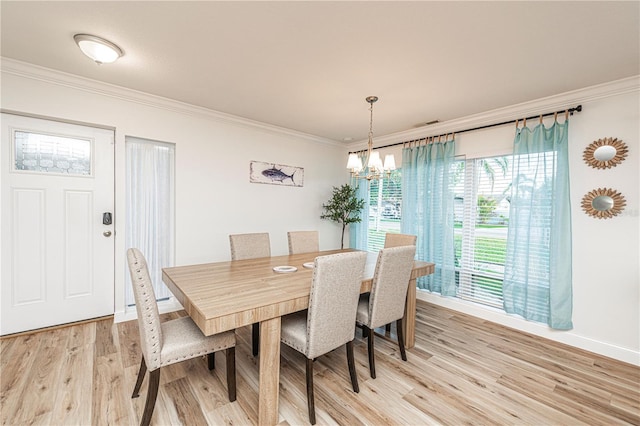 dining room with a chandelier, light wood finished floors, crown molding, and baseboards