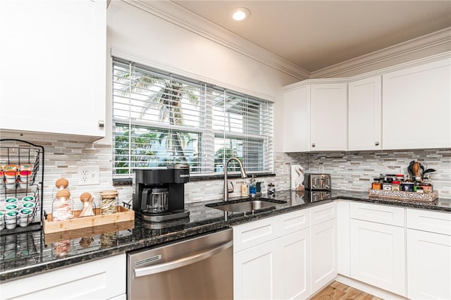 kitchen featuring backsplash, dishwasher, a sink, crown molding, and white cabinetry