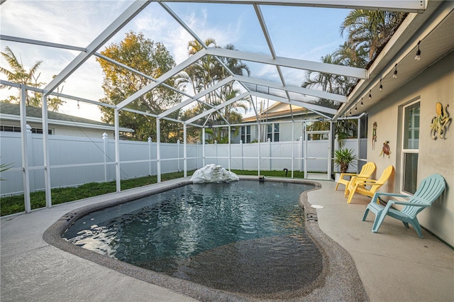 view of swimming pool with a fenced backyard, a fenced in pool, glass enclosure, and a patio