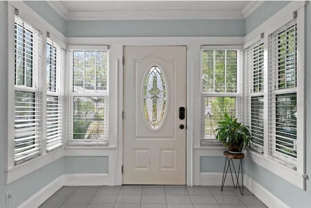 entryway with crown molding, baseboards, and light tile patterned flooring