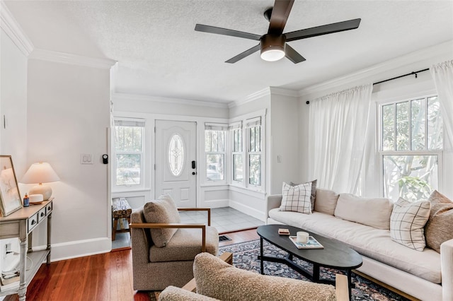 living area with crown molding, baseboards, a ceiling fan, and hardwood / wood-style flooring
