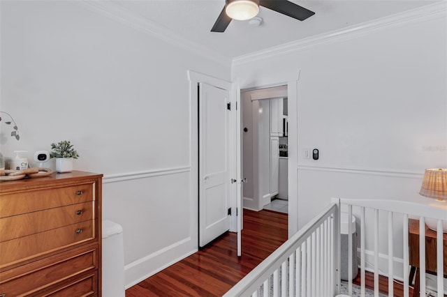 bedroom with a nursery area, wood finished floors, crown molding, and a ceiling fan