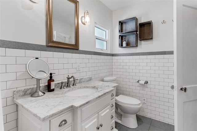 bathroom with vanity, tile walls, a wainscoted wall, toilet, and tile patterned flooring