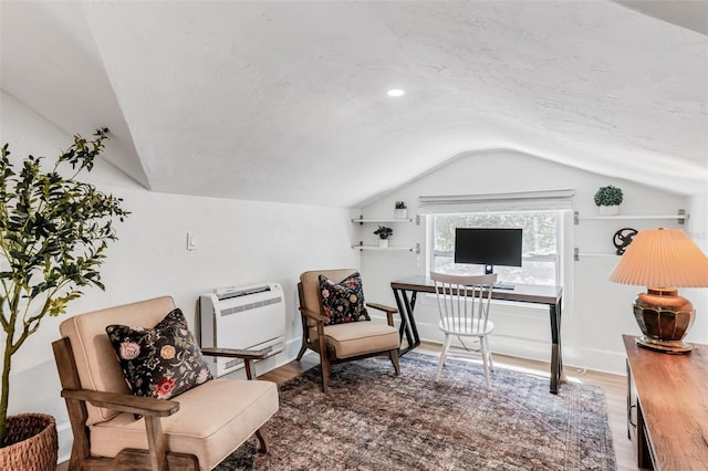 home office featuring lofted ceiling, wood finished floors, and heating unit