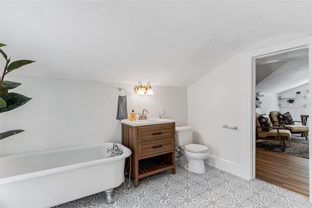 full bathroom featuring lofted ceiling, a freestanding tub, vanity, and toilet