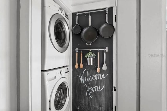 clothes washing area featuring stacked washer and clothes dryer