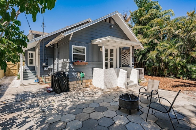 back of property featuring a patio and an outdoor fire pit