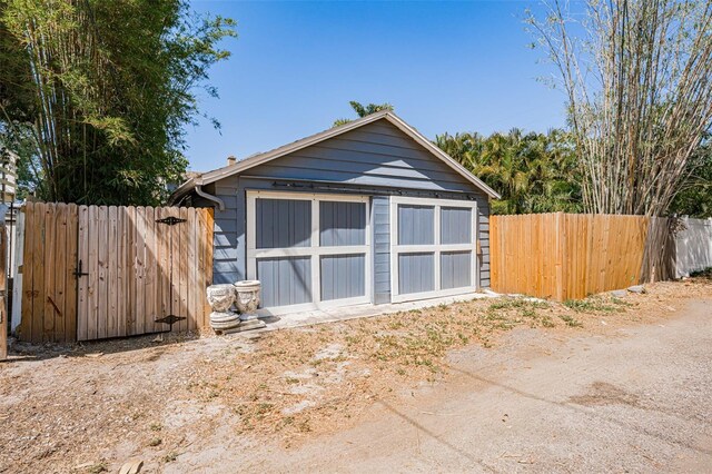 garage featuring fence and a storage shed