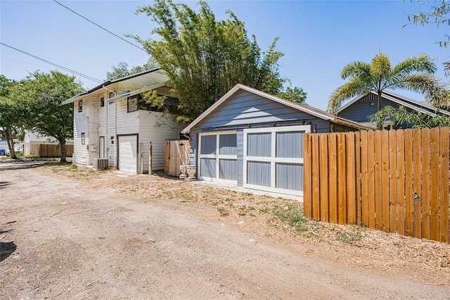 detached garage featuring central air condition unit and fence