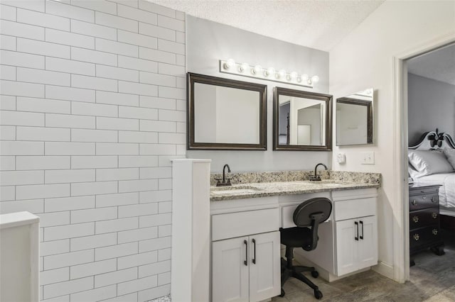 bathroom featuring connected bathroom, double vanity, a textured ceiling, and a walk in shower