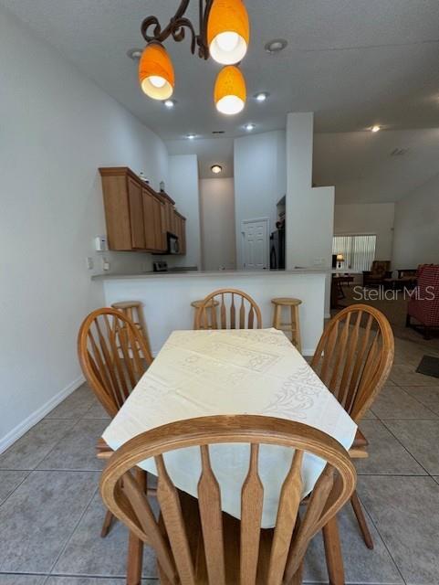 dining room featuring baseboards and light tile patterned flooring