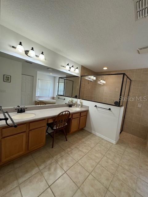 bathroom with tile patterned flooring, walk in shower, and a textured ceiling