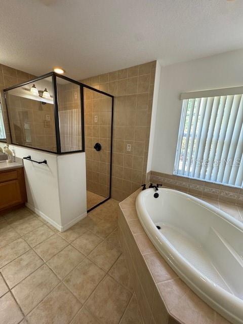 full bathroom with vanity, a walk in shower, tile patterned flooring, and a garden tub