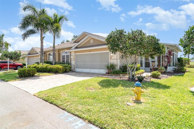 ranch-style home featuring concrete driveway, stucco siding, a front lawn, and a garage