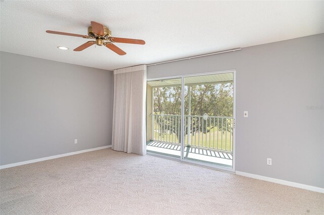 carpeted empty room with a ceiling fan and baseboards