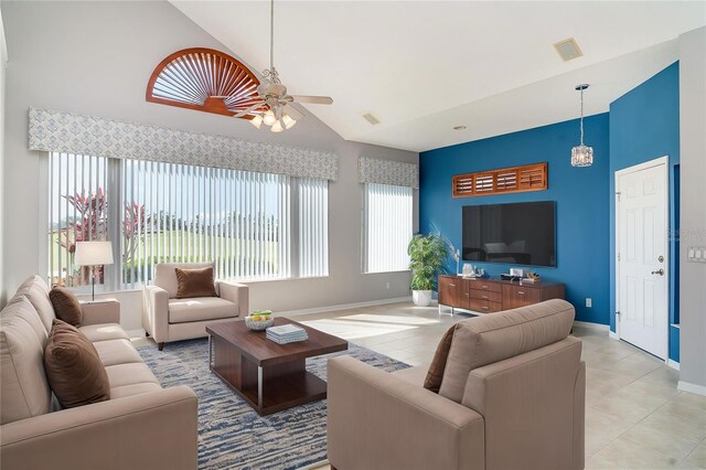 living area with baseboards, a ceiling fan, high vaulted ceiling, and light tile patterned flooring