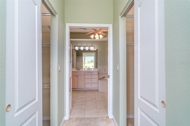 hallway featuring a sink and light tile patterned flooring